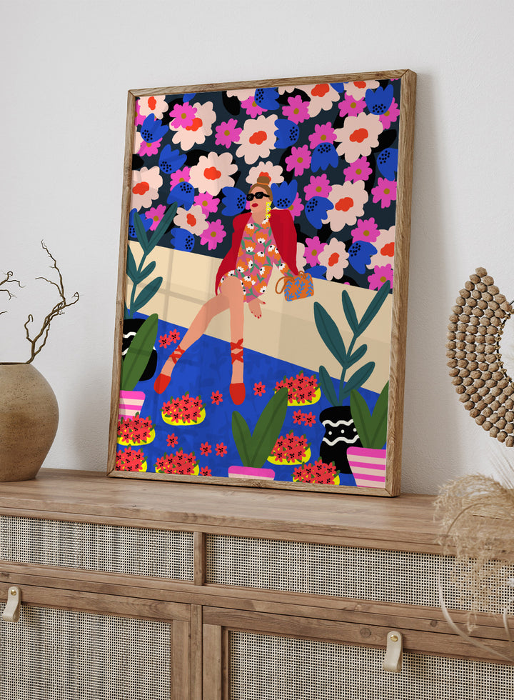 Colorful illustration of a woman sitting on a bench with floral and plant patterns. Bold and Blooming by Rafaela Mascaro fine art print poster featuring woman in vibrant floral garden by water, modern contemporary botanical wall art.