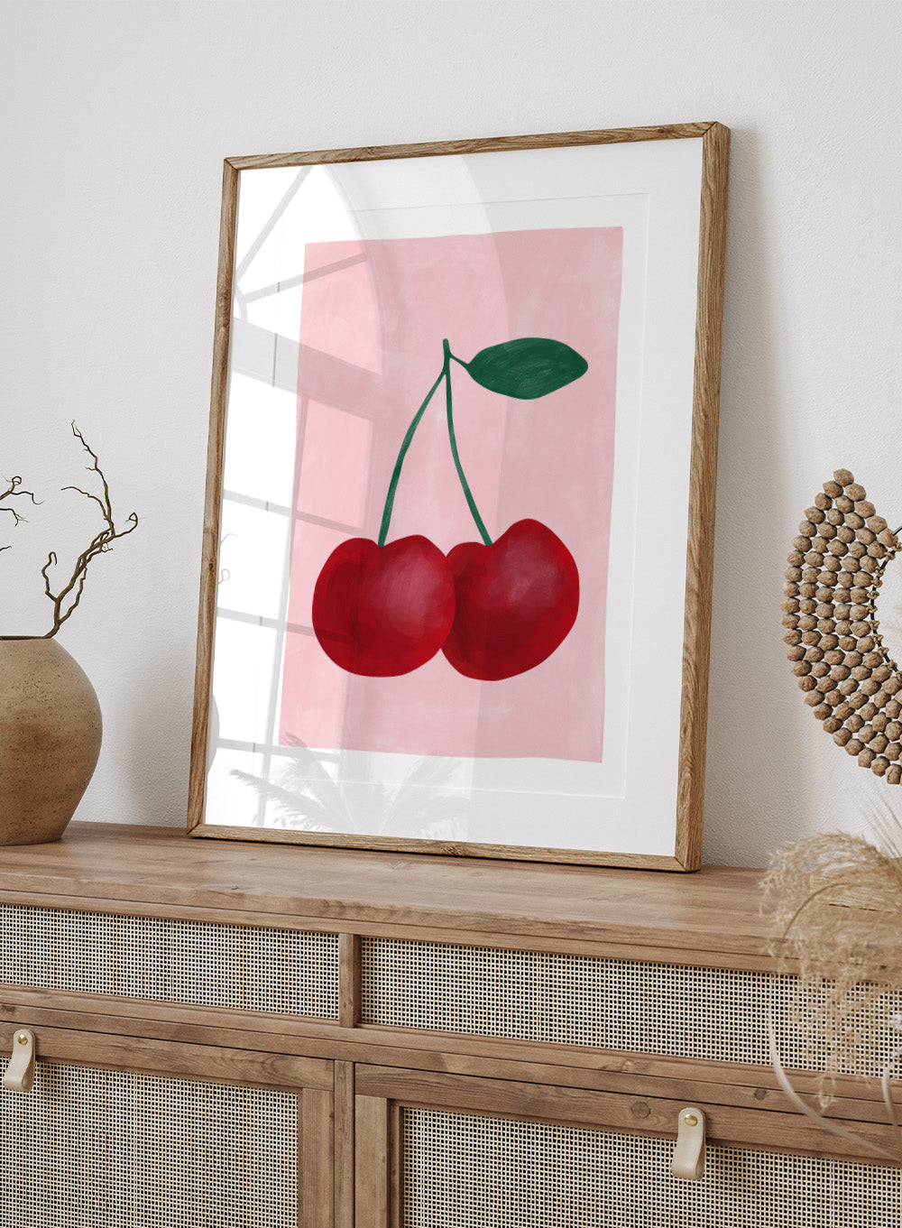 Two red cherries with a green stem on a pink background. Red cherries art print by Elena Ristova featuring two hand-painted cherries with green stems on a soft pink background. Officially licensed minimalist wall poster.