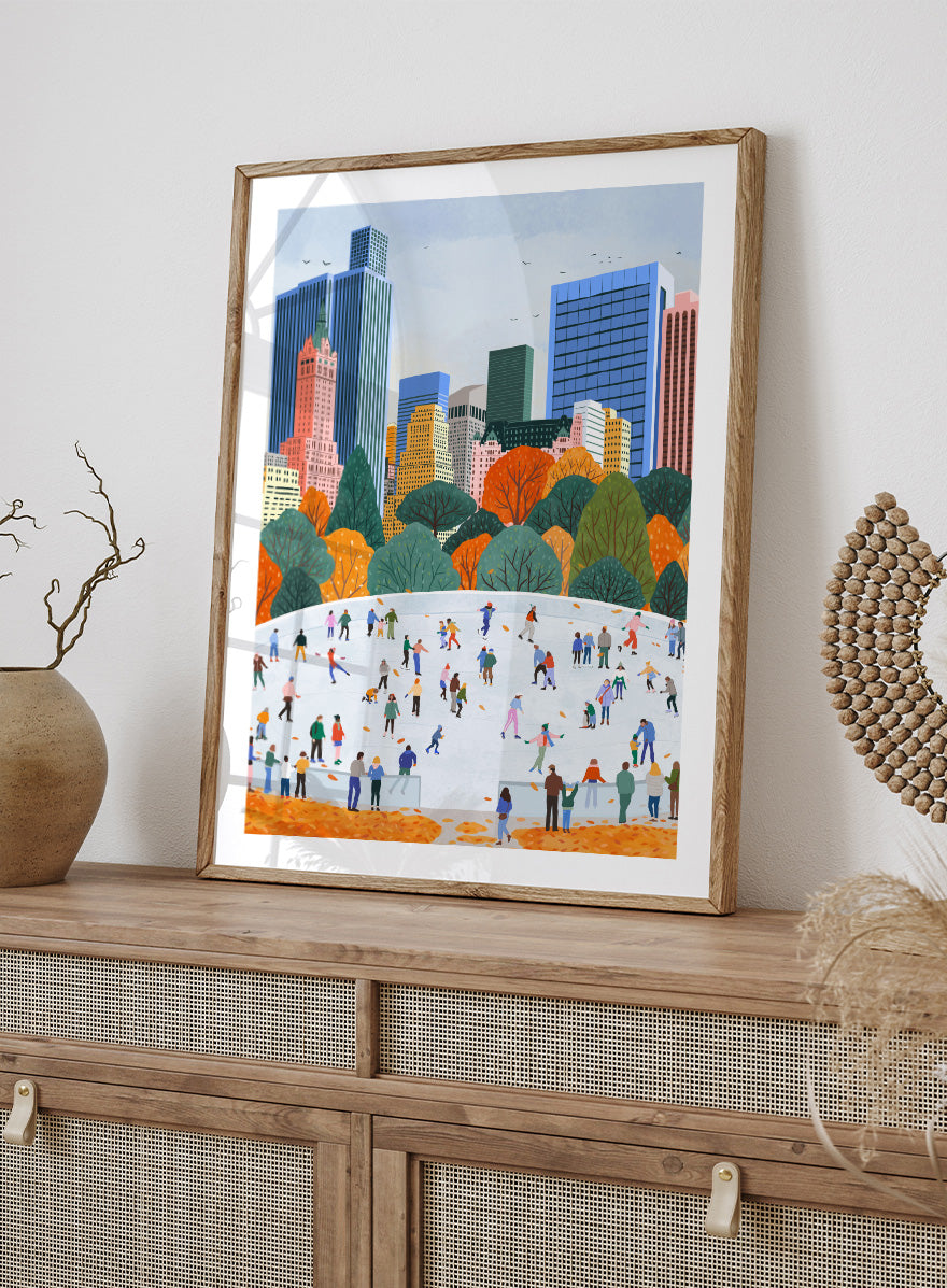 A framed art print depicting a city skyline with autumn trees and a large white ice rink filled with small illustrated people skating. Autumn City Ice Skating by Ceyda Alasar city art print featuring a lively outdoor rink, fall trees, skaters, and a colorful urban skyline.