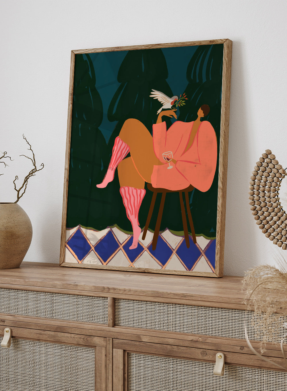 Illustration of a person in a pink dress sitting on a stool with a glass of wine, holding a dove with an olive branch. A Lil Birdy Told Me by Arty Guava is a modern woman art print with a bird, pink robe, and bold color. Officially licensed wall poster.