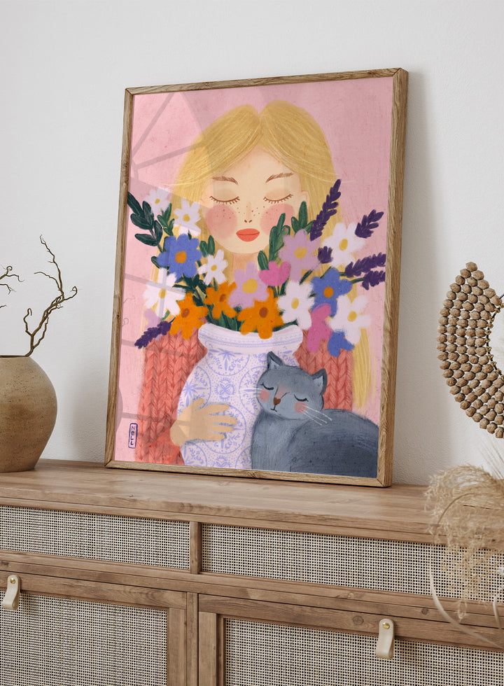 Illustration of a woman holding a vase of flowers and a cat on a pink background. Dreamy Girl Cat Flowers by Dirkie Nell is a colorful floral portrait art print featuring hand painted flowers, a sleepy cat, and soft contemporary illustration details.
