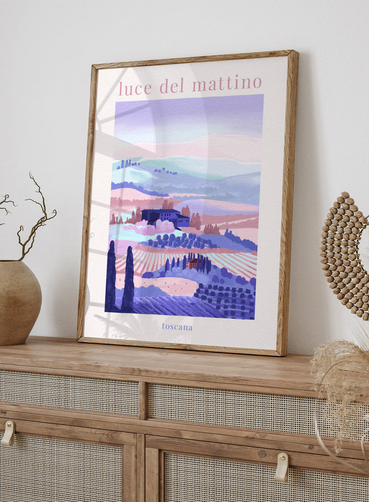 Artistic depiction of a Tuscan landscape with rolling hills and a farmhouse, labeled 'luce del mattino toscana'. Tuscany Morning by Goed Blauw is a landscape art print and wall poster featuring rolling hills, fields, and houses in soft pastel tones inspired by the Italian countryside.