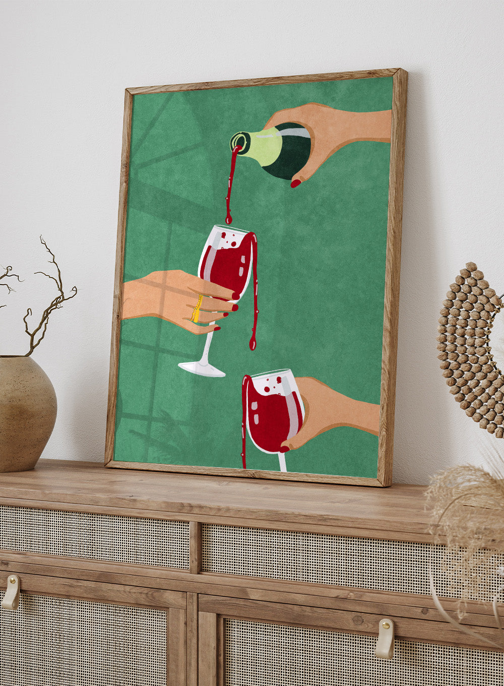 Illustration of hands pouring red wine into glasses on a green background. Cheers Girls by Raissa Oltmanns is a modern wine art print featuring bold red glasses and contemporary girl dinner party wall poster style.