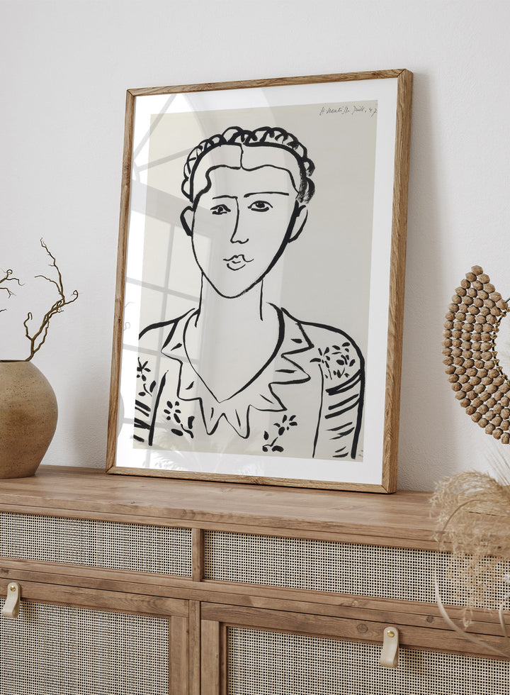 Black line drawing of a woman's portrait on a white background. Portrait de femme by Henri Matisse is a minimalist portrait art print featuring expressive black linework, modern French design, and iconic mid century style.