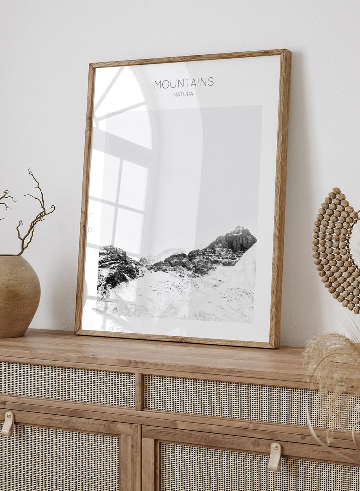 Black and white mountain landscape with 'Mountains Natura' text. Serene Peaks by The MIUUS Studio is a black and white mountain photography art print and wall poster featuring snowy peaks, minimalist composition, and modern neutral design.