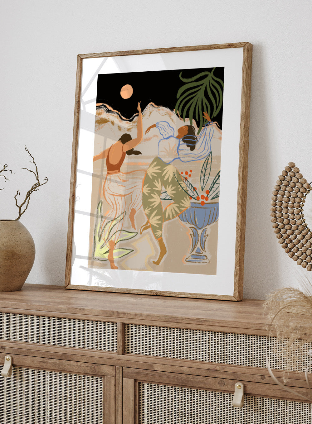 Artistic depiction of two figures dancing with plants and a vase in the background. Moonlight Dance by Arty Guava is a modern illustration art print featuring dancing women, moon imagery, floral elements, and contemporary wall art design.
