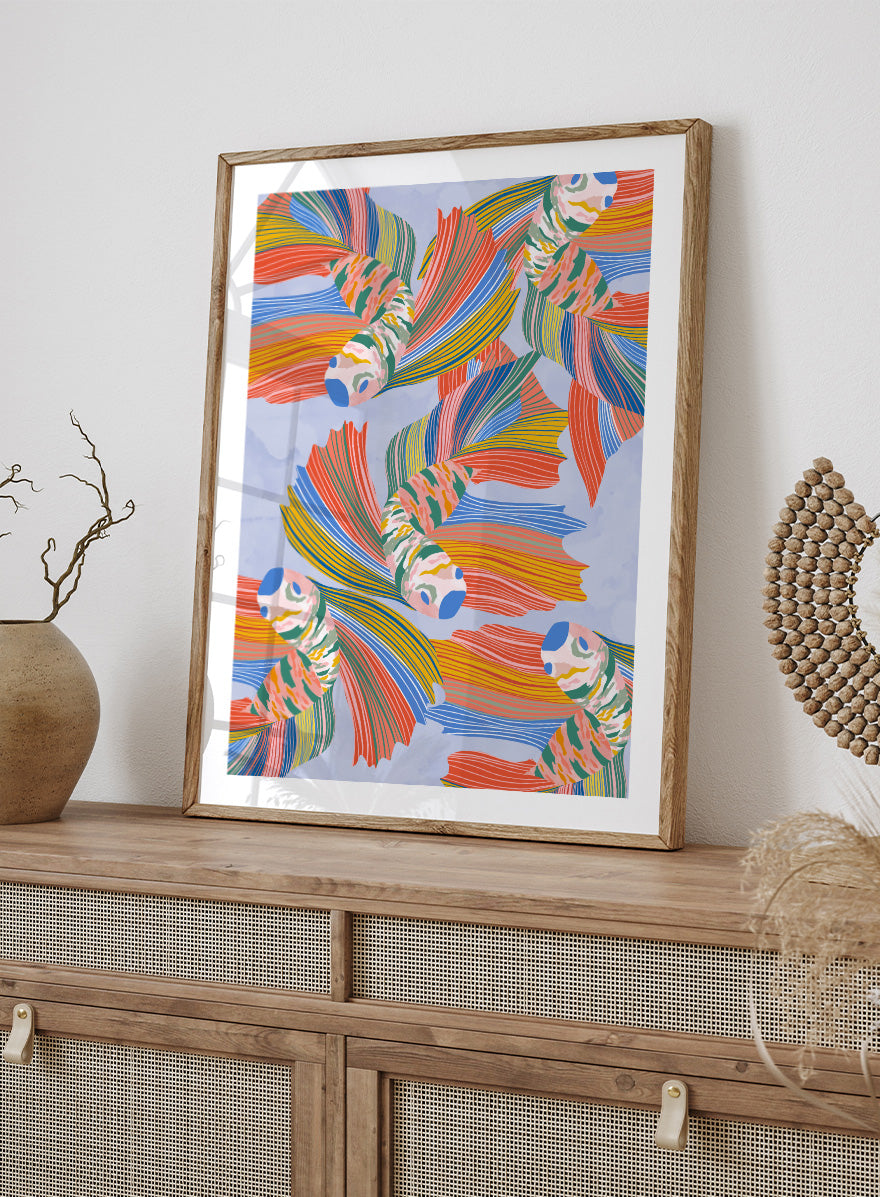 A framed art print featuring a colorful pattern of stylized fish with flowing striped fins in orange, yellow, green, blue, and red on a light blue background. Vibrant Swirling Fish Pattern by Ceyda Alasar art print featuring colorful flowing fish, striped fins, and playful aquatic movement on a soft blue background.