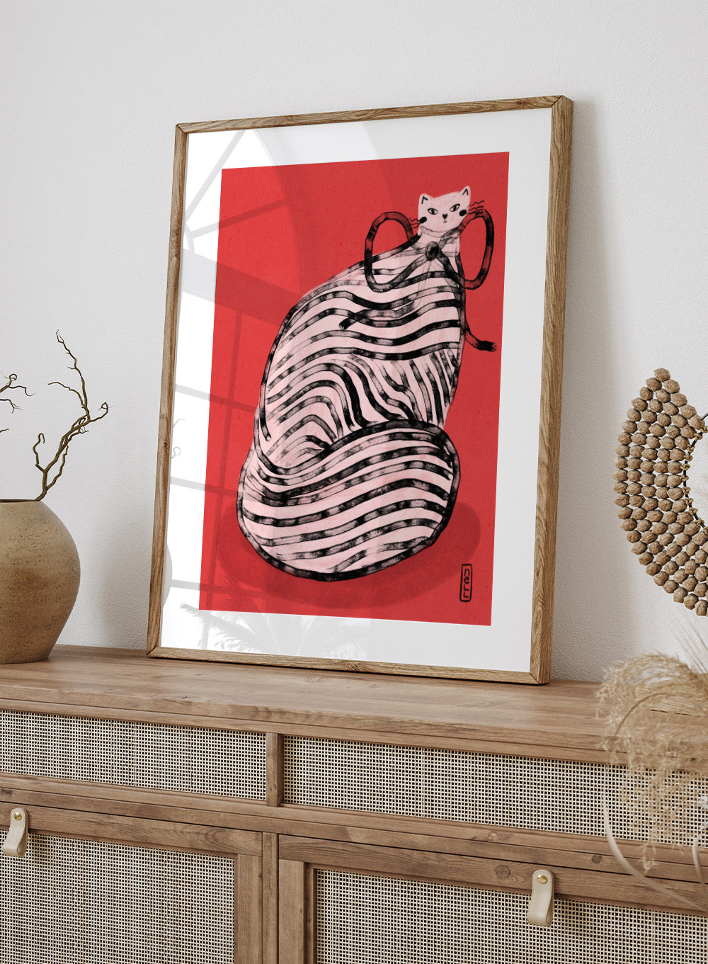 Illustration of a cat inside a ball of yarn on a red background. Black and White Striped Cat by Dirkie Nell is a playful cat art print featuring bold stripes and a red background. A colorful modern animal wall poster.