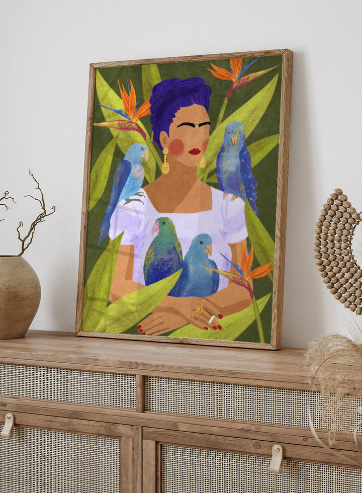 Artistic depiction of a woman with blue hair surrounded by parrots and tropical plants. Frida and Birds by Raissa Oltmanns is a modern Frida Kahlo inspired art print with tropical birds and bold botanical wall poster design.