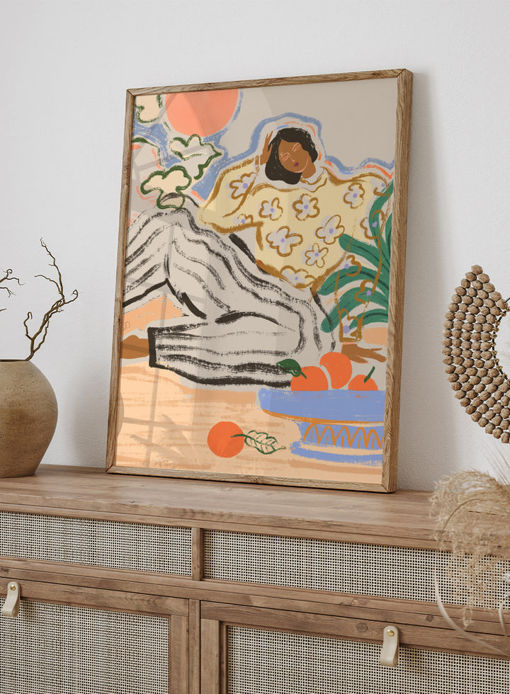 Artistic depiction of a person lounging on a beach with a bowl of fruit and flowers. Lazy Days by Arty Guava is a modern woman art print with warm colors, oranges, and relaxed still life details. Officially licensed wall poster.