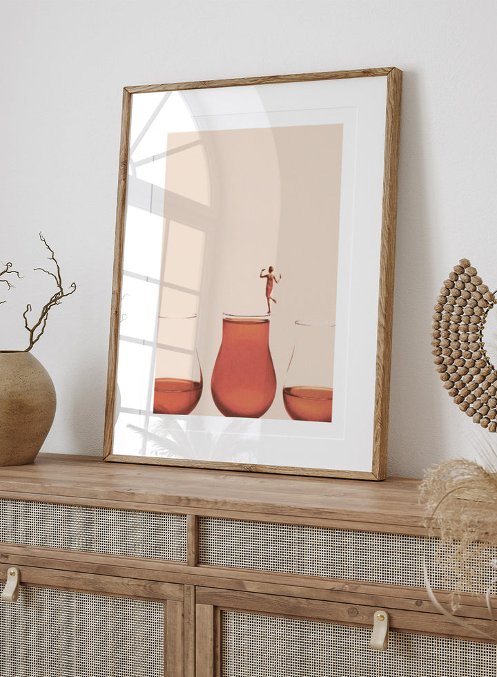 I Prefer the Full One by Maarten Léon collage art print featuring a woman standing on a full glass. Premium fine art print with real wood framing.