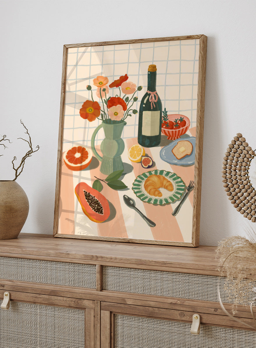 A stylized still life illustration showing a bottle, flowers in a pitcher, fruit, bread, and tableware on a striped surface against a grid background. Colorful Breakfast Still Life by Katarzyna Gąsiorowska art print featuring fruit, flowers, a croissant, and colorful kitchen tableware in soft modern tones.