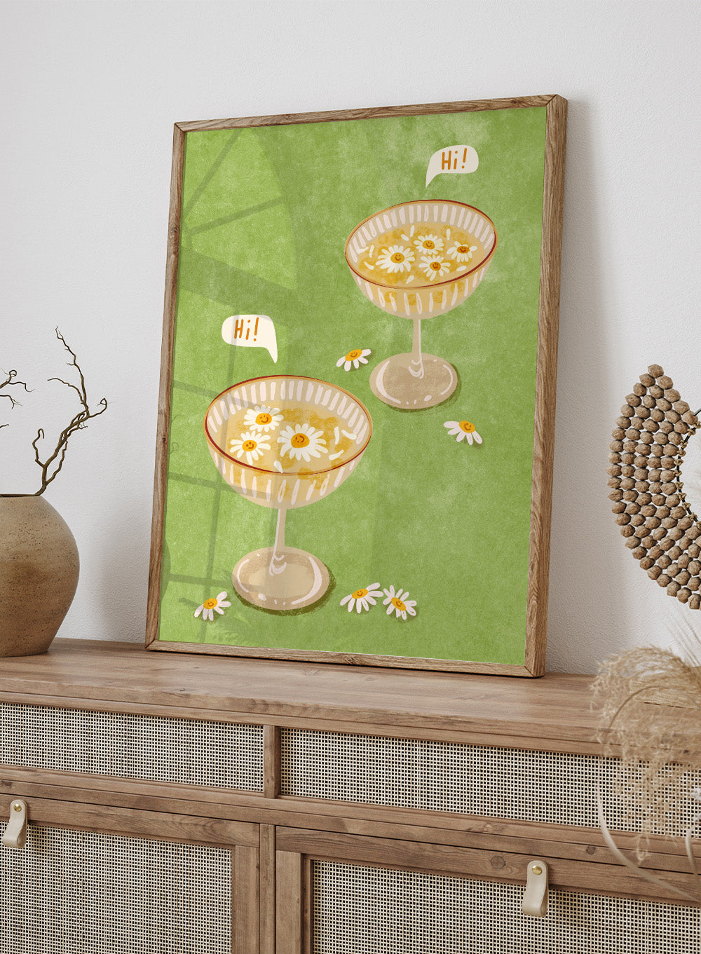 Illustration of two cocktail glasses with daisies on a green background. Hi by Raissa Oltmanns is a modern cocktail art print featuring smiling daisy drinks in playful contemporary wall poster style.