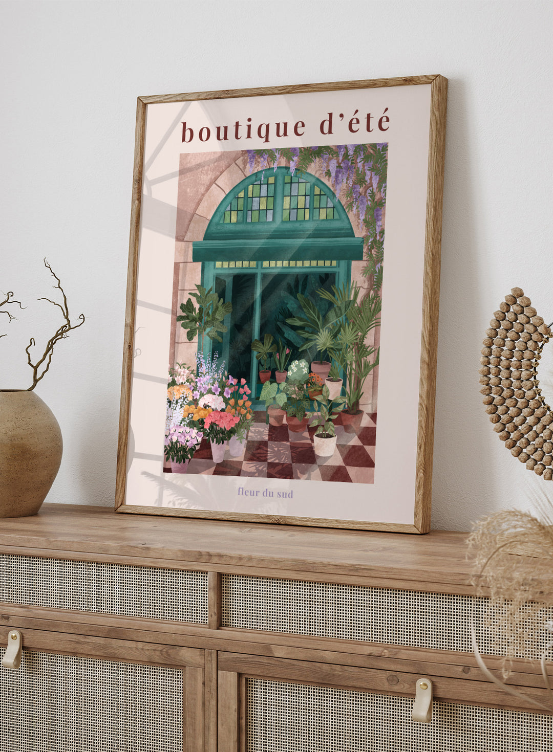 Illustration of a charming store entrance with plants and flowers, featuring the text 'boutique d'été' and 'fleur du sud'. French Flower Shop by Goed Blauw is a colorful storefront art print and wall poster featuring plants, flowers, and a green arch window in a warm European style setting.