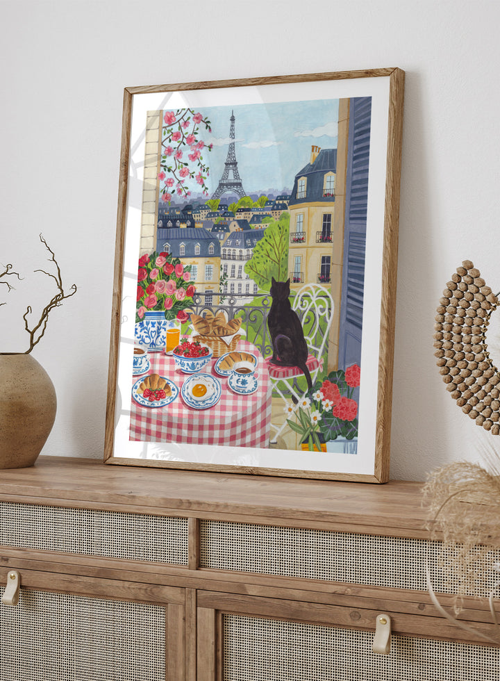 Parisian scene with a cat, table setting, and Eiffel Tower view. Paris Balcony Breakfast by Caroline Bonne Müller is a colorful Paris art print featuring Eiffel Tower view, breakfast table, cat illustration, and modern aesthetic city scene.