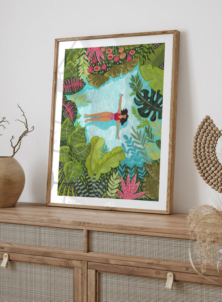 Illustration of a woman swimming in a pool surrounded by tropical plants. Tropical Pool Relaxation by Caroline Bonne Müller is a fine art print and wall poster of a woman floating in a pool surrounded by tropical plants.