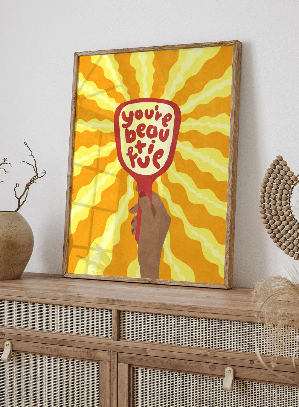 Hand holding a sign with 'You're beautiful' on an orange and yellow background. Beautiful by Raissa Oltmanns is a modern motivational art print featuring a hand mirror illustration, bold lettering, and bright statement wall poster style.
