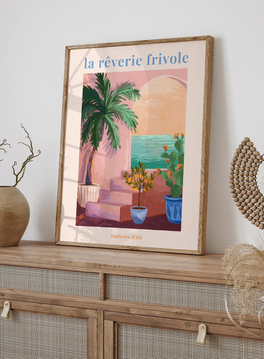 Artistic depiction of a tropical scene with palm trees and plants, featuring the text 'la rçverie frivole'. La Rêverie Frivole Palm by Goed Blauw is a coastal art print and wall poster featuring a palm tree, citrus plant, and ocean view in warm summer tones.