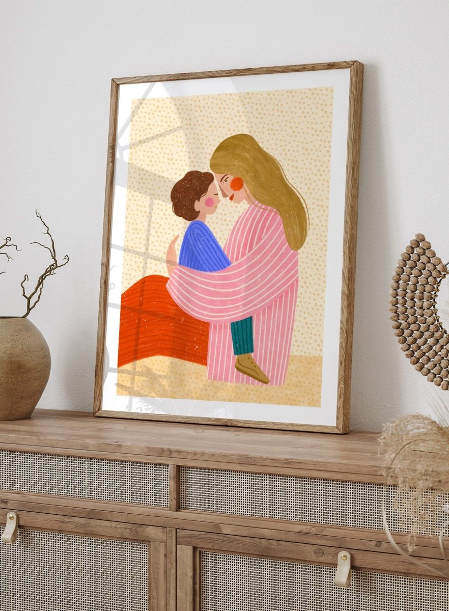 A framed art print featuring a stylized illustration of a woman in a pink striped robe embracing a child in a blue sweater. Loving Mother Child Embrace by Bea Müller premium framed fine art print featuring a mother holding her child close in warm, colorful tones.