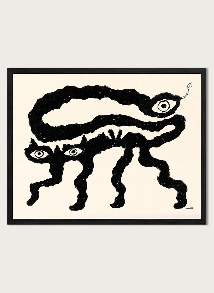 Framed artwork of a black and white creature with cat-like features and snake-like body. I Am Animals by Eden Kalif is a modern minimalist line art print featuring abstract animal forms in a bold black and white contemporary wall poster design.