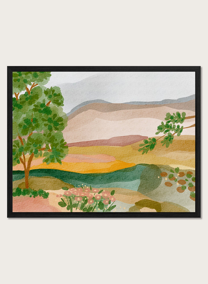 A framed landscape art print featuring a stylized watercolor scene with green trees, layered hills, and a river. Shop Peaceful Valley View by Nikita Jariwala, a serene landscape wall art print poster featuring rolling hills, distant mountains, wildflowers, and soft green tones.