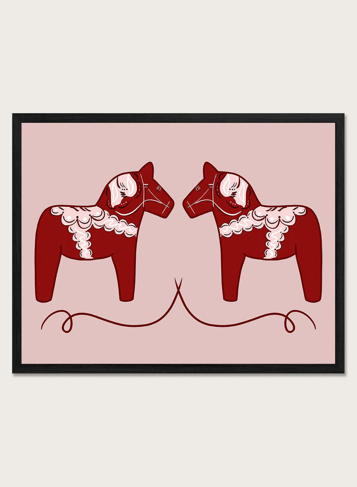 Two red Dala horse figures with white patterns on a pink background. Nordic Horses Twins by Athene Fritsch is a Scandinavian folk art illustration art print featuring Swedish Dala horses, bold red color, and modern wall art design.