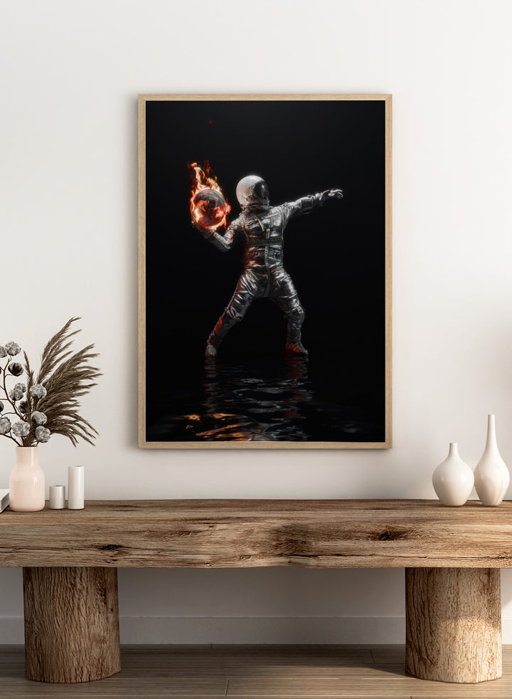Person in a silver suit holding a flaming sphere against a black background. Astronaut Burning Earth by Nicebleed is a surreal astronaut art print featuring a flaming planet, dark background, and modern sci-fi aesthetic poster design.