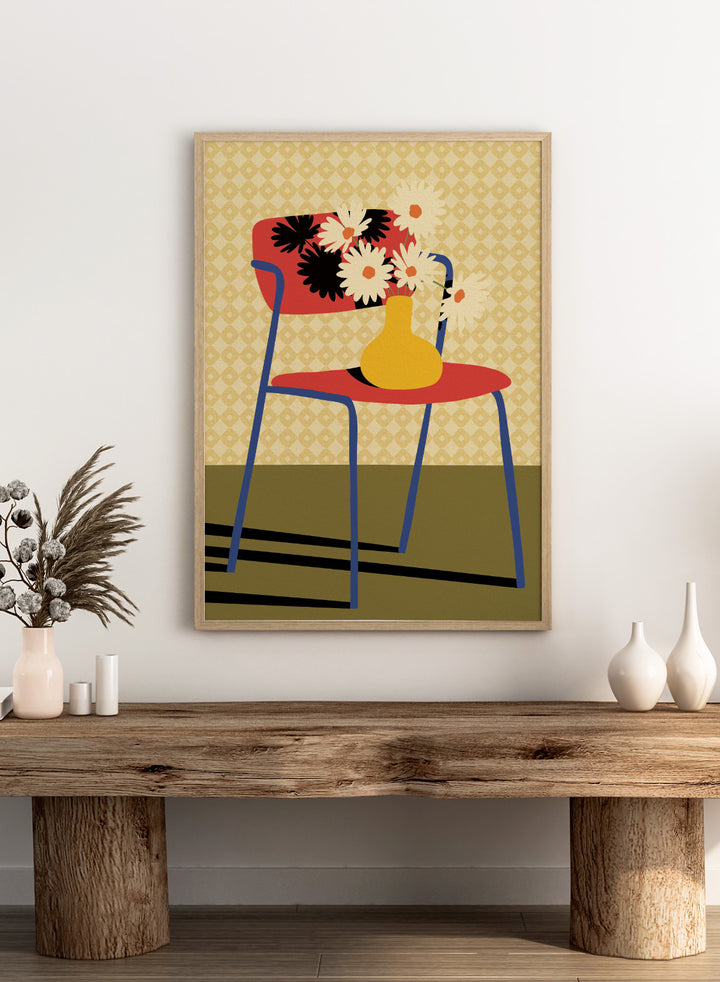 A stylized art print depicting a blue chair with a red seat and backrest, holding a yellow vase filled with white daisies, set against a patterned beige wallpaper and olive green floor. Colorful Chair Still Life by Lisa Solomoniuk premium framed fine art print featuring a red chair, yellow vase, white flowers, and bold graphic color.