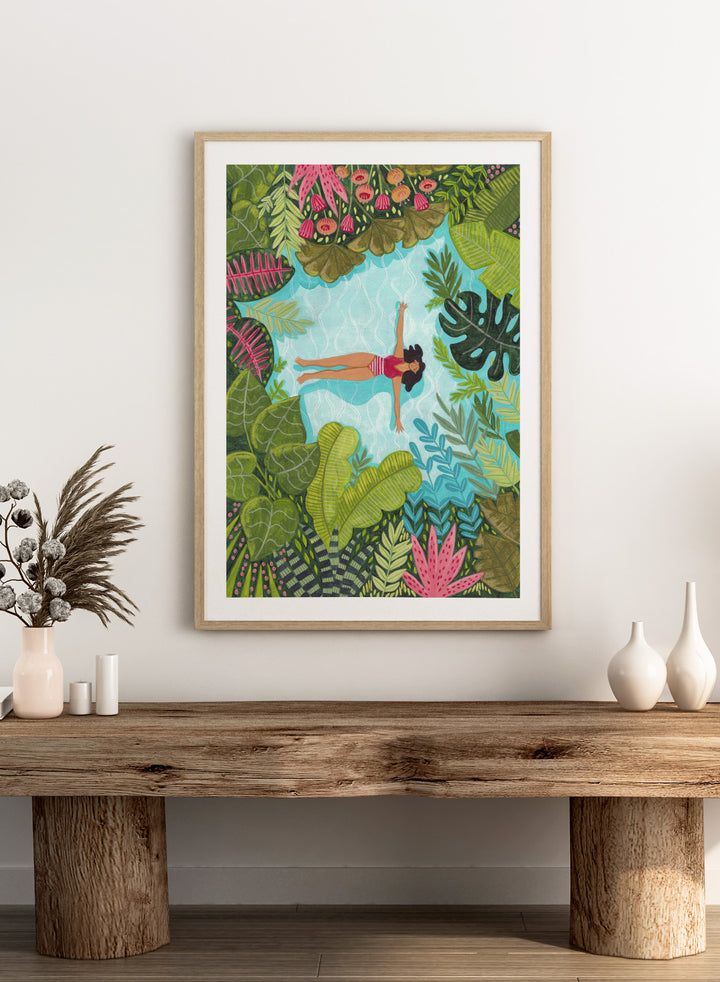 Illustration of a woman swimming in a pool surrounded by tropical plants. Tropical Pool Relaxation by Caroline Bonne Müller is a fine art print and wall poster of a woman floating in a pool surrounded by tropical plants.
