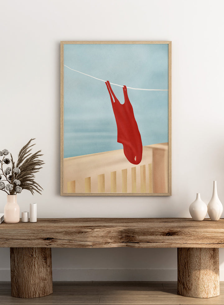 Red swimsuit hanging on a clothesline against a blue sky. Red Swimsuit On Balcony by Flow Line features a red swimsuit drying in the sun, bringing Mediterranean charm and summer vacation style to your walls.