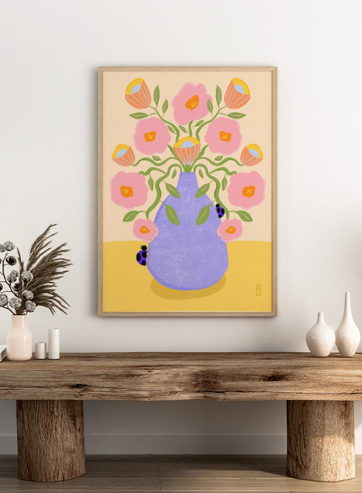 A stylized floral art print showing pink flowers with orange centers and green stems arranged in a light purple vase on a pale yellow surface. Shop Pink Flowers Ladybugs by Dirkie Nell, a colorful floral art print featuring pink flowers, a lavender vase, green stems, and playful ladybugs.