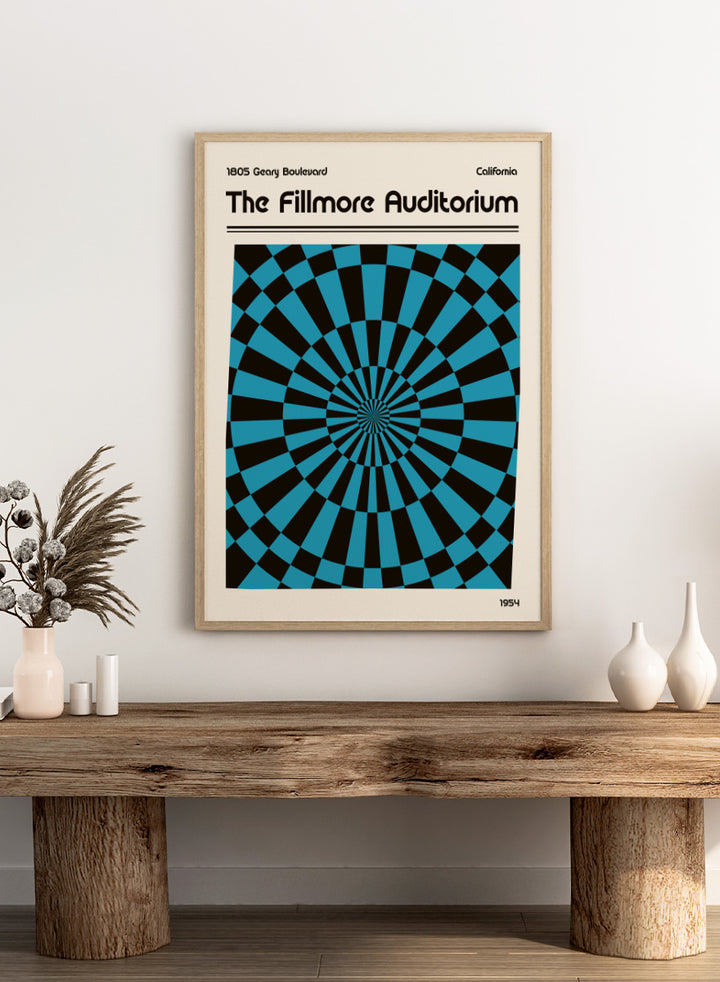 A poster-style graphic for The Fillmore Auditorium, with black text on a cream background and a large central optical illusion pattern in turquoise blue and black radiating inward. Text at the top reads &