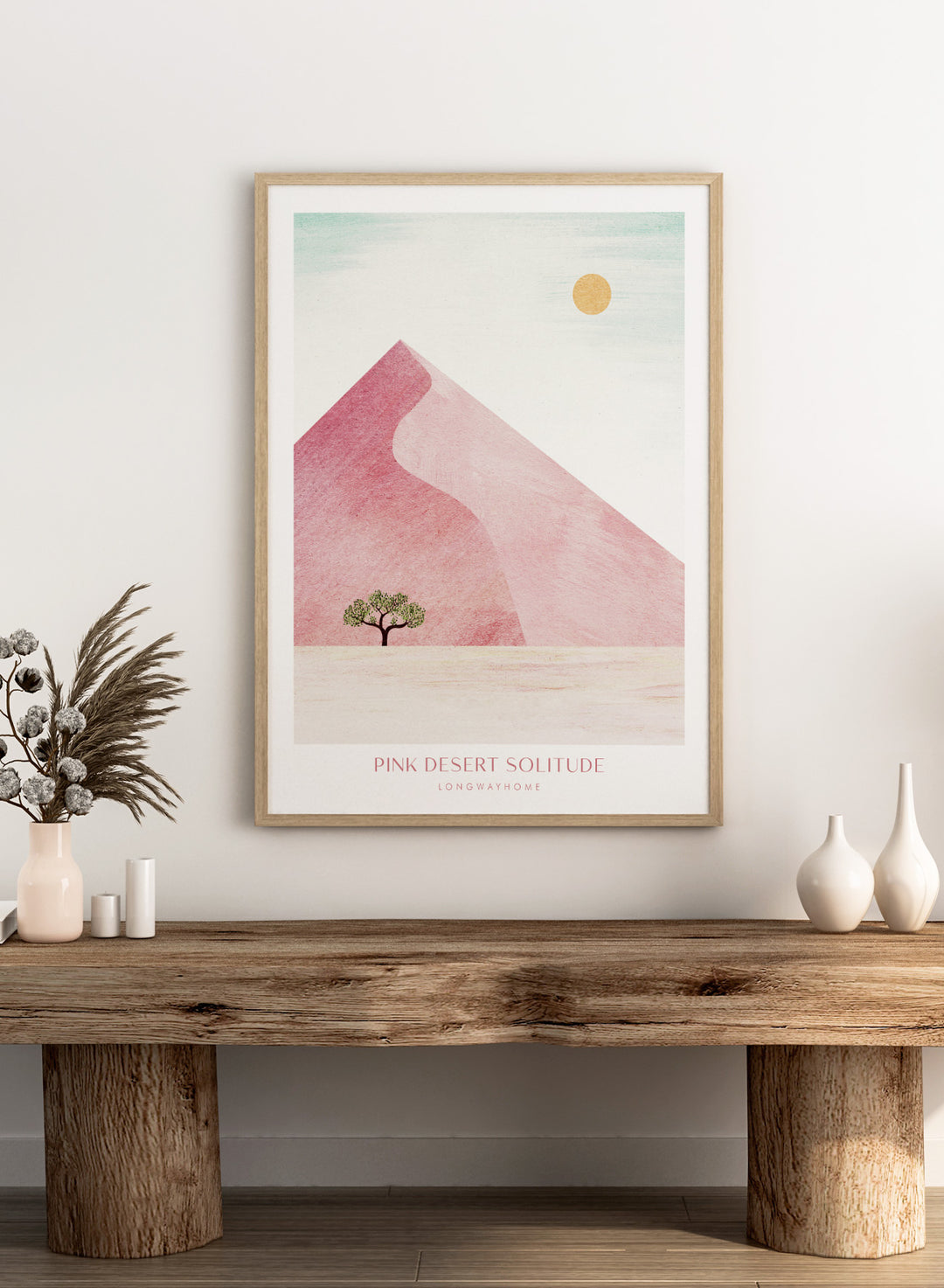 Artistic depiction of a pink desert with a solitary tree and a yellow sun. Pink Desert Solitude by Longwayhome is a minimalist desert art print featuring soft pink dunes, abstract landscape scenery, and calming modern design.
