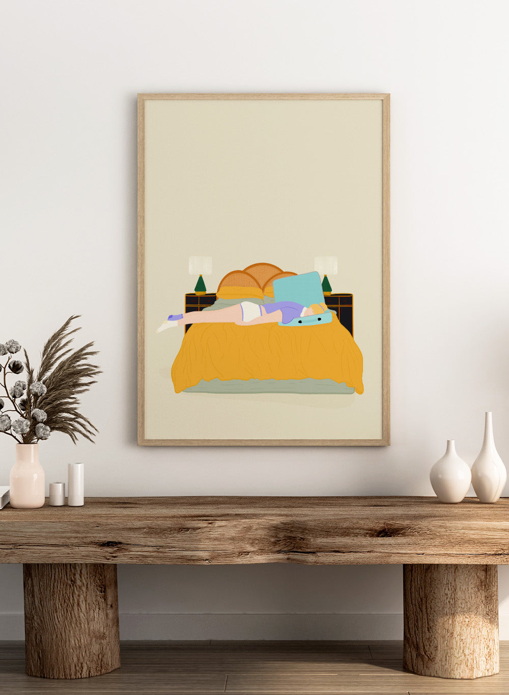 Illustration of a person lying in bed with a blue pillow and yellow blanket on a beige background. Digital Nomad by Jota de Jai is a calm modern art print of a woman resting on a bed with an open suitcase, officially licensed fine art wall poster with framing available.