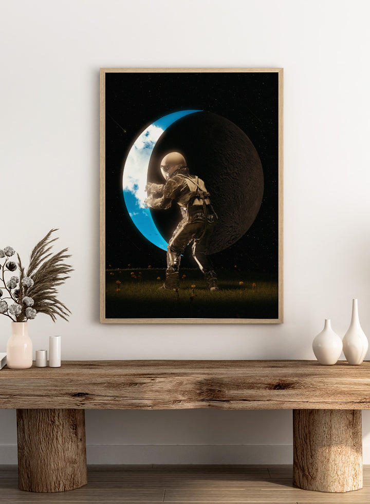 Astronaut standing on a moon-like surface with Earth visible through a crater. Astronaut Holding the Moon by Nicebleed is a surreal space art print featuring an astronaut pushing a crescent moon, modern aesthetic wall poster.