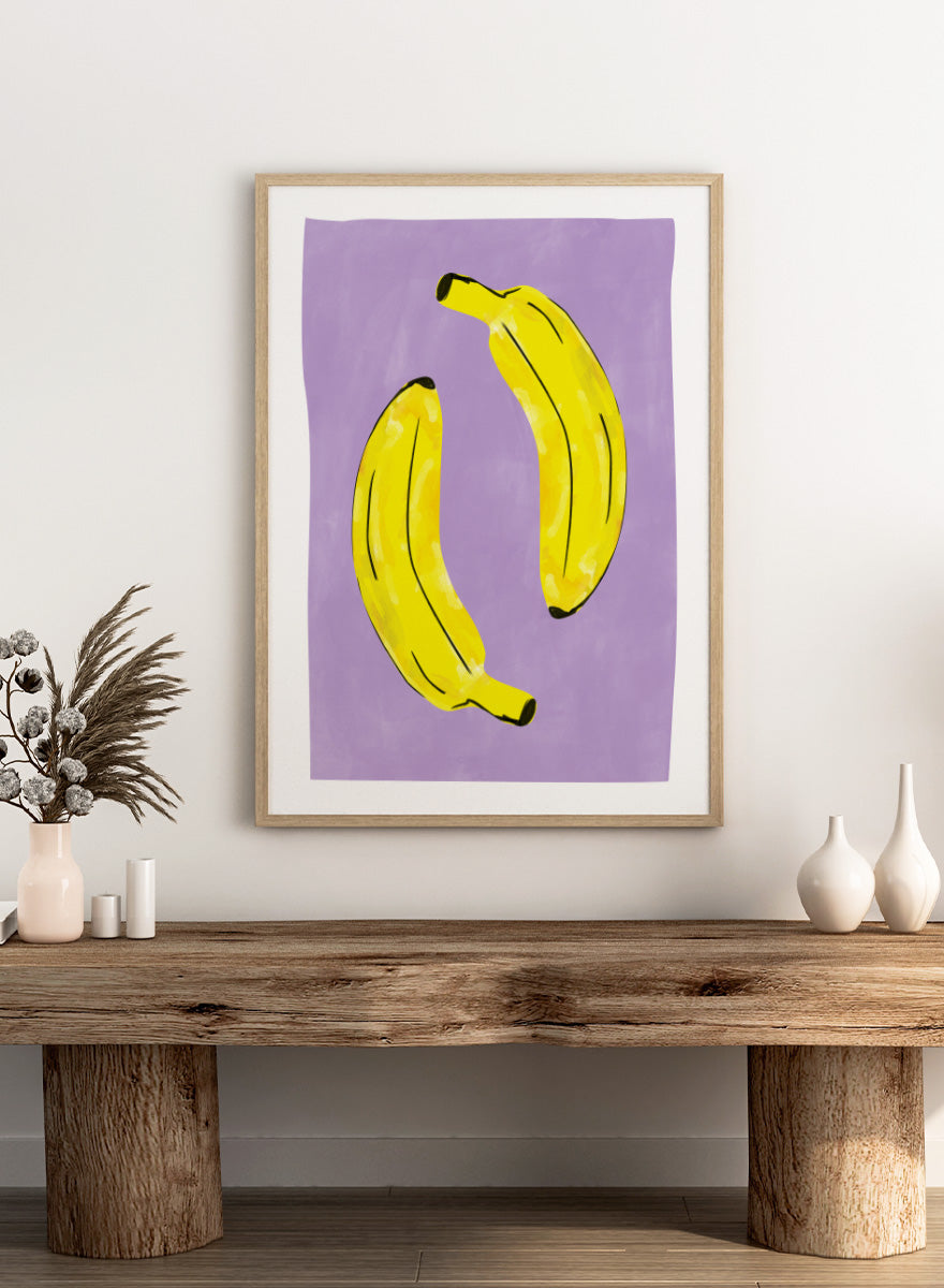 Shop Playful Purple Bananas by Elena Ristova, a colorful banana wall art print poster featuring two bright yellow bananas on a soft purple background with bold black details.
