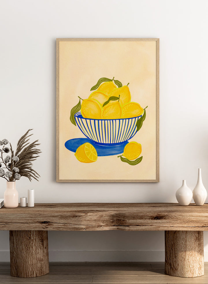 A stylized still life illustration of yellow lemons in a blue-and-white striped bowl with green leaves. Shop Fresh Lemon Bowl by Nikita Jariwala, a kitchen wall art print poster featuring bright yellow lemons, a blue striped bowl, green leaves, and citrus still life.