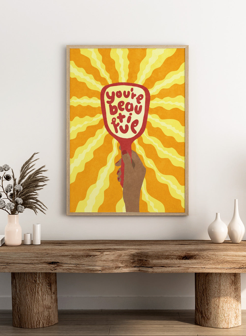 Hand holding a sign with 'You're beautiful' on an orange and yellow background. Beautiful by Raissa Oltmanns is a modern motivational art print featuring a hand mirror illustration, bold lettering, and bright statement wall poster style.