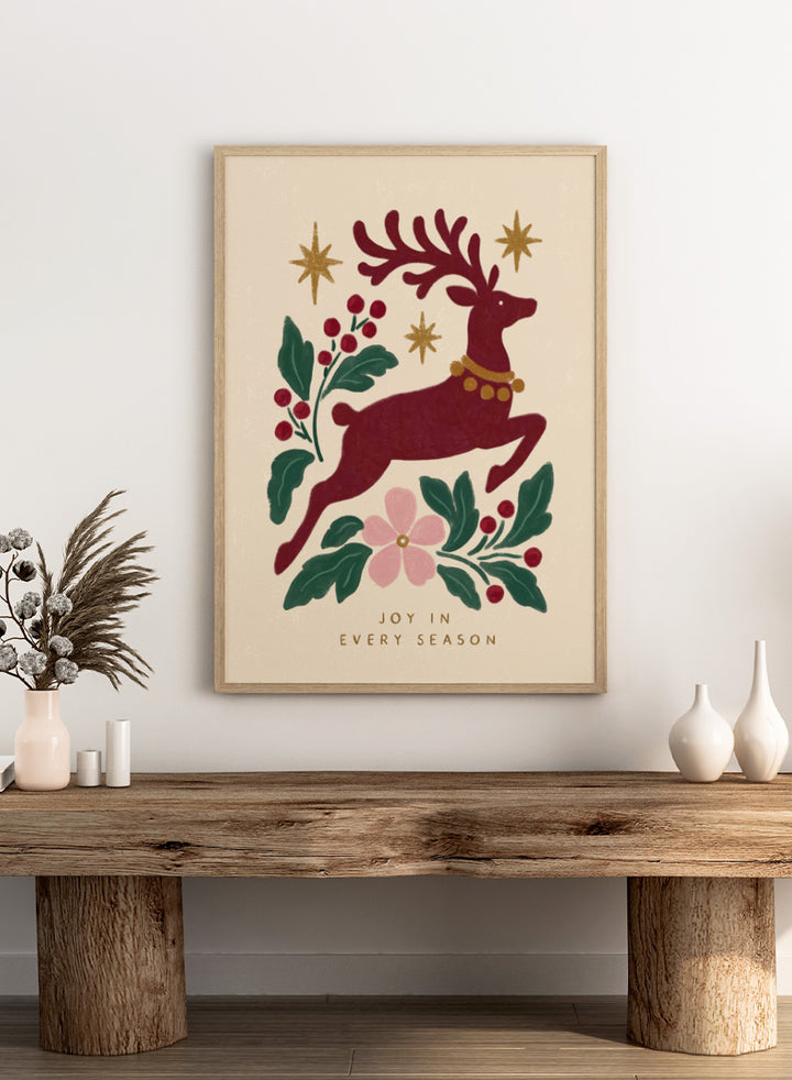Shop Jumping Reindeer Joy by Katarzyna Gąsiorowska, a Christmas wall art print poster featuring a leaping reindeer, berries, greenery, stars, and festive holiday charm.