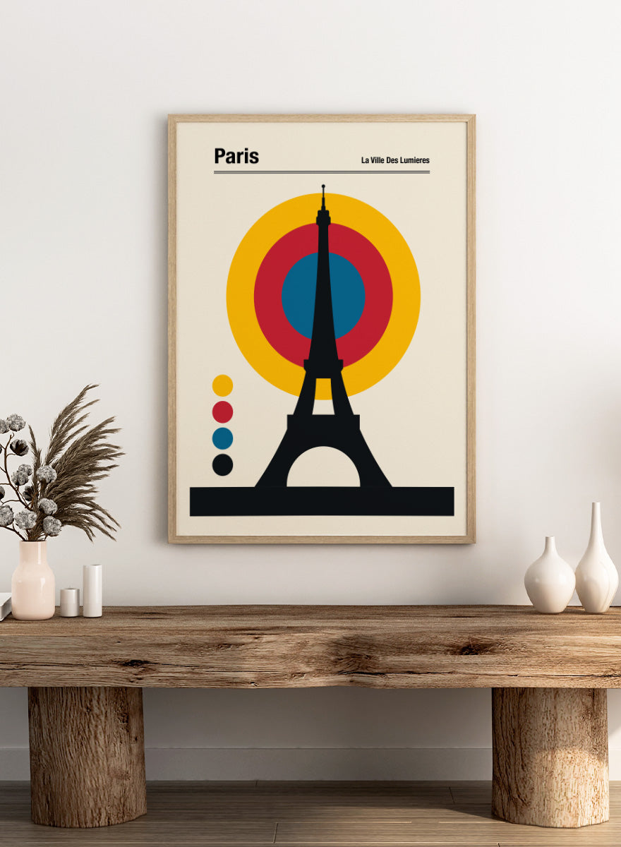 A minimalist Paris poster featuring a black Eiffel Tower silhouette in front of concentric yellow, red, and blue circles on a cream background, with the text &