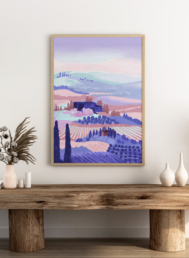 Painting of a landscape with rolling hills, buildings, and cypress trees in pastel colors. Tuscany by Goed Blauw is a landscape art print and wall poster featuring rolling hills, fields, and countryside homes in soft pastel tones.
