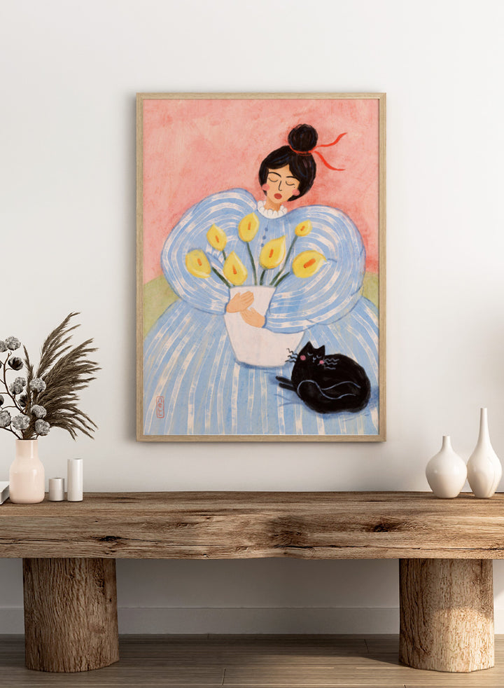 A stylized painting of a woman in a voluminous light blue dress holding a white vase with yellow flowers, with a black cat at her side against a pink background. Woman With Flowers And Cat by Dirkie Nell is a colorful portrait and floral art print featuring a woman, yellow flowers, blue dress, and black cat.