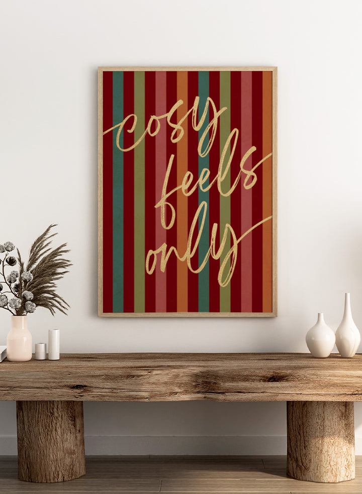 Shop Cosy Feels Christmas by Dominique Vari, a colorful holiday wall art print poster featuring retro stripes, gold lettering, and festive red and green tones.