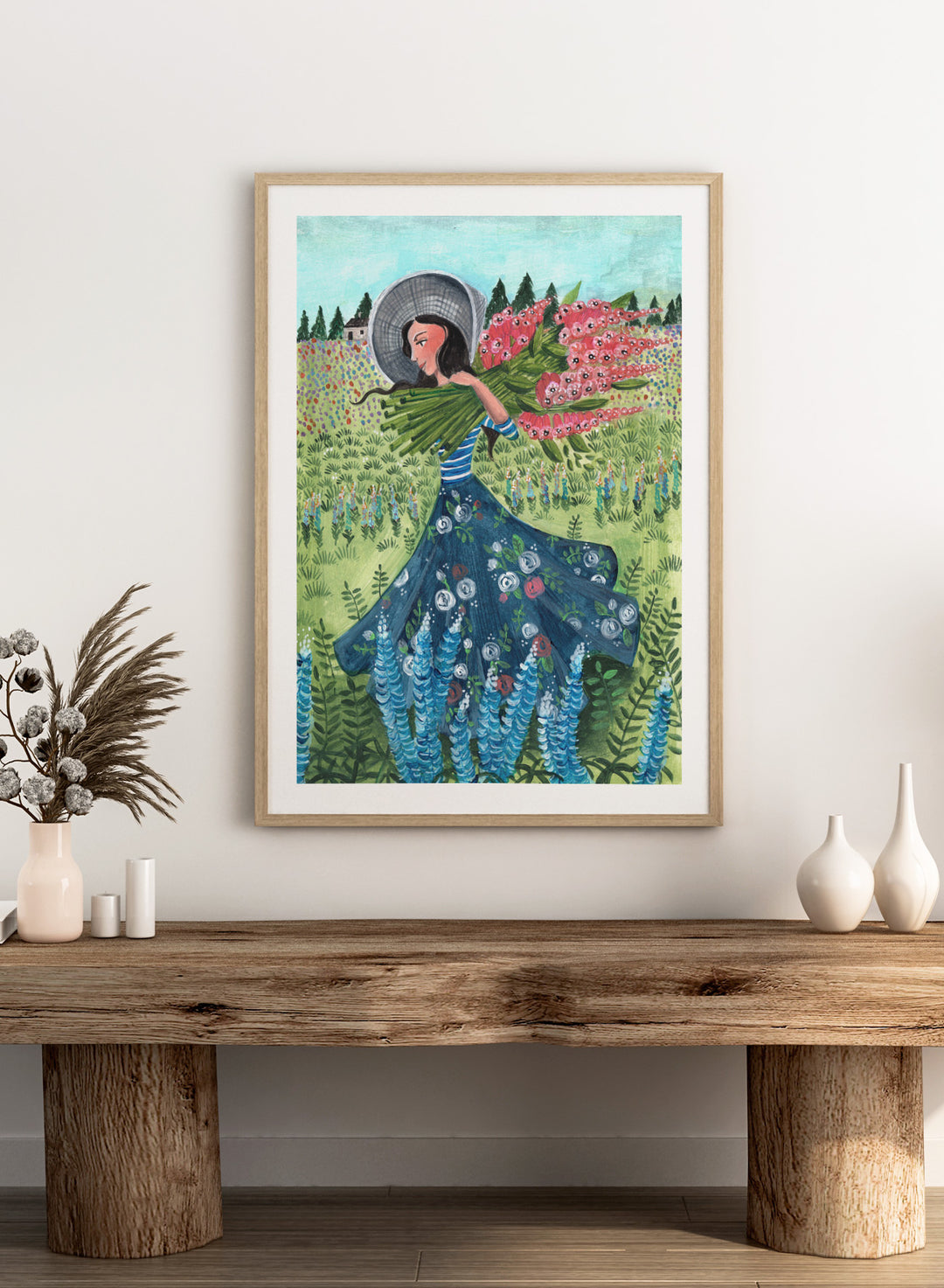 Woman in a floral dress holding flowers in a garden. Woman With Summer Flowers by Caroline Bonne Müller is a fine art print and wall poster featuring a woman carrying flowers through a colorful field.