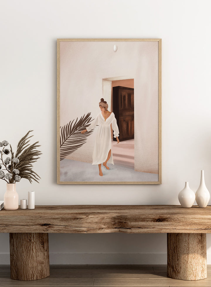 Woman in a white dress standing in a doorway with a palm leaf in the foreground. Woman With Palm Leaf by City Art is a modern figurative art print featuring a woman in a white dress, tropical greenery, warm neutrals, and Mediterranean style.