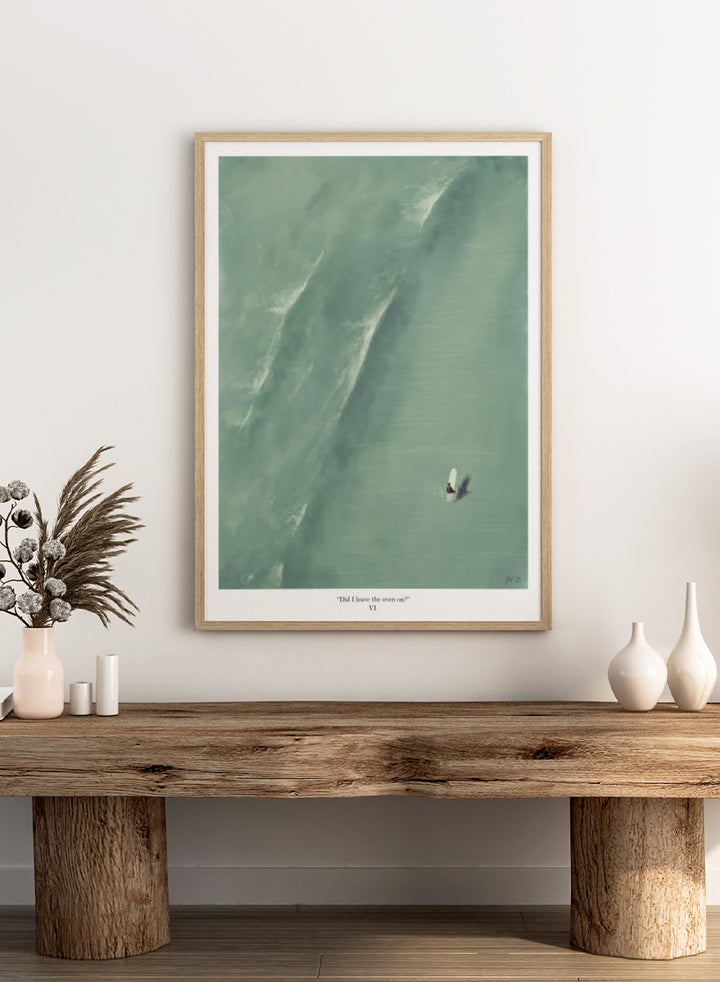 A framed art print featuring a minimalist aerial illustration of a surfer on a large wave, with the caption &