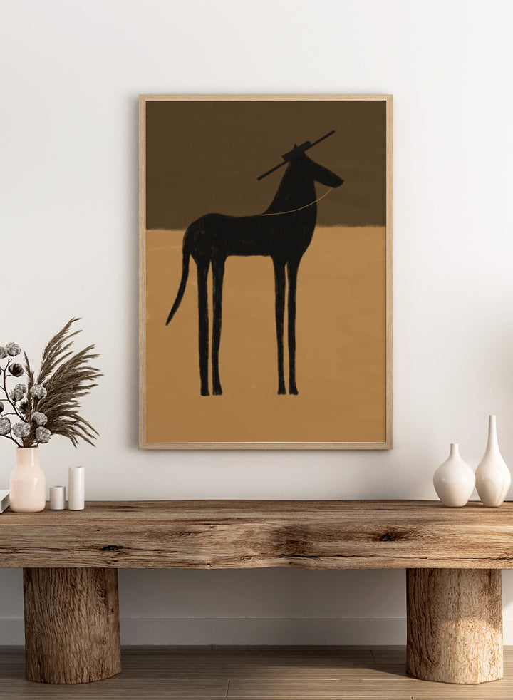 A minimalist art print featuring a black silhouette of a long-legged animal, possibly a zebra or antelope, standing against a two-tone brown background. The Unspoken Story by The Art Concept animal art print featuring a tall black horse in a wide hat against warm brown and sand tones.