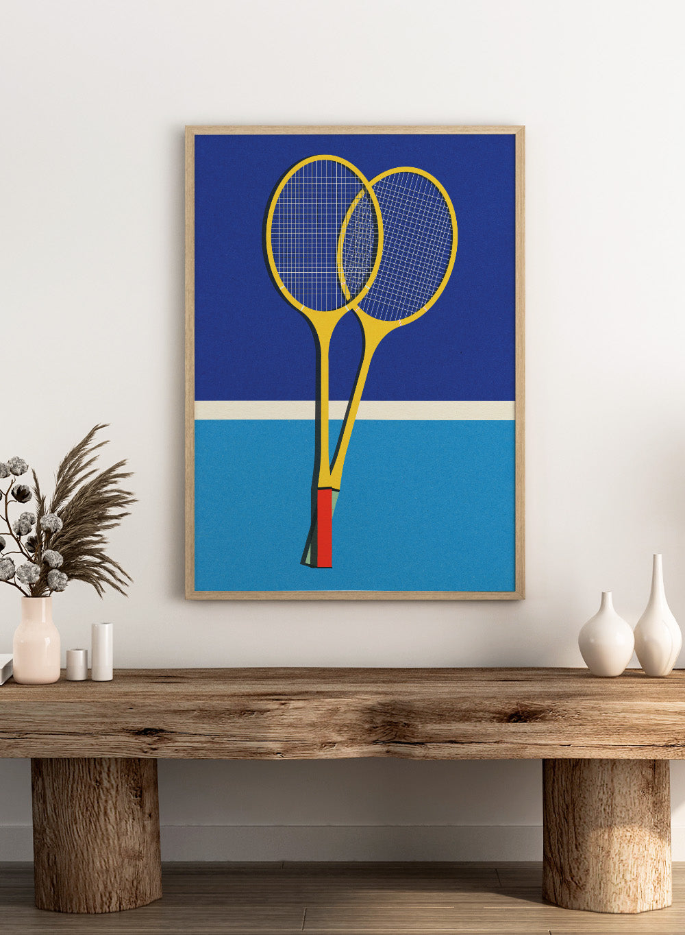 Two yellow badminton rackets on a blue background with a white stripe at the bottom. Wooden Badminton Rackets by Rosi Feist is a modern minimalist fine art print featuring bold yellow rackets on a graphic blue court. Officially licensed wall poster with optional artisan framing.
