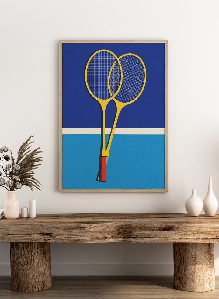 Two yellow badminton rackets on a blue background with a white stripe at the bottom. Wooden Badminton Rackets by Rosi Feist is a modern minimalist fine art print featuring bold yellow rackets on a graphic blue court. Officially licensed wall poster with optional artisan framing.