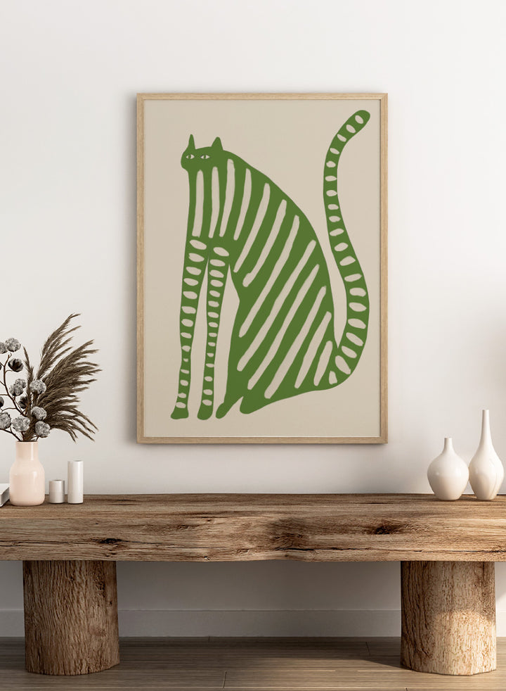 A stylized green cat illustration with vertical cream stripes and dotted details on a beige background. Playful Green Striped Cat by The Art Concept cat art print featuring an elongated green cat with cream stripes, long legs, and an oversized curved tail.